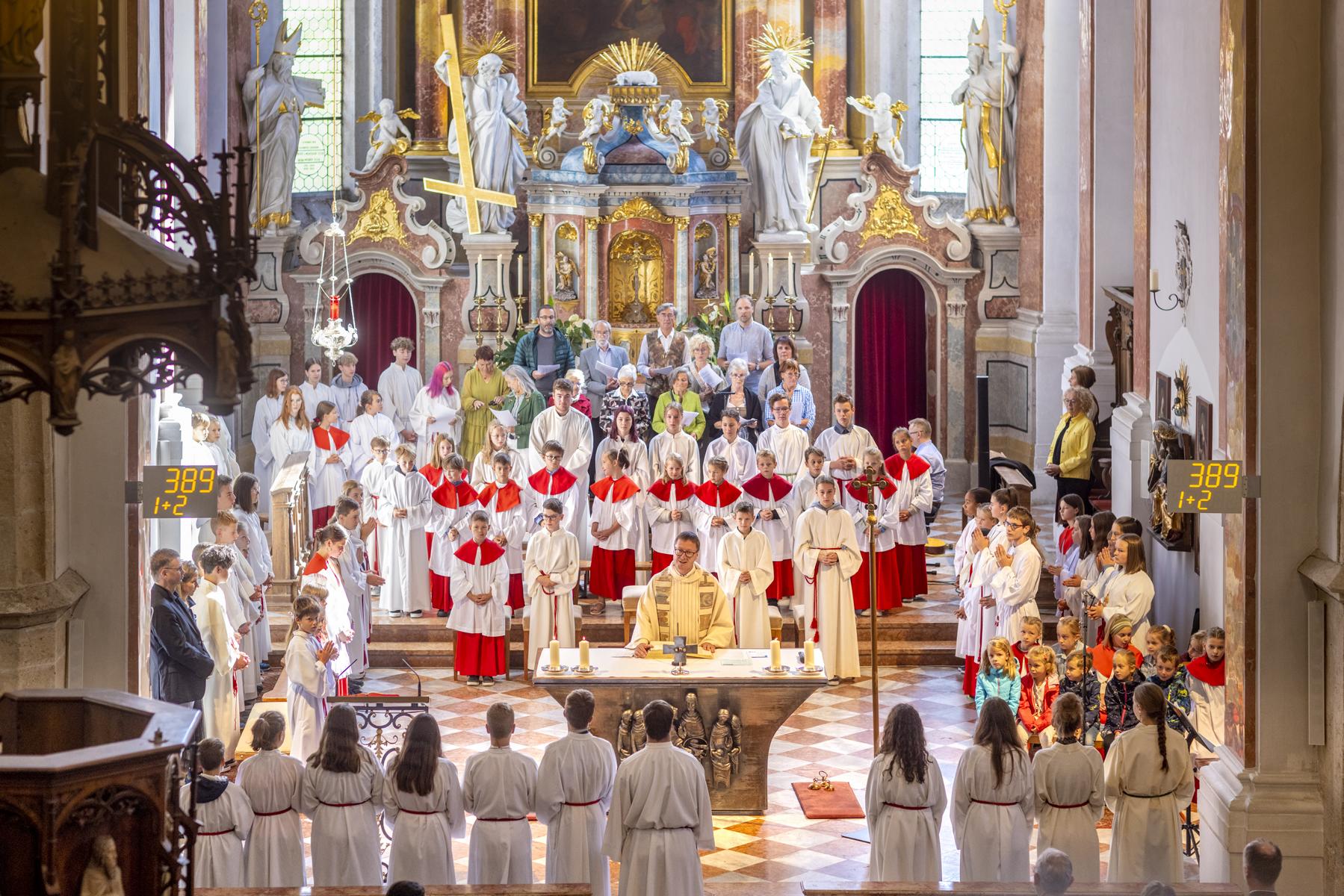 Gottesdienst in der Kirche St. Andrä. Blick zum Altar mit Pfarrer, Ministranten und Musikern