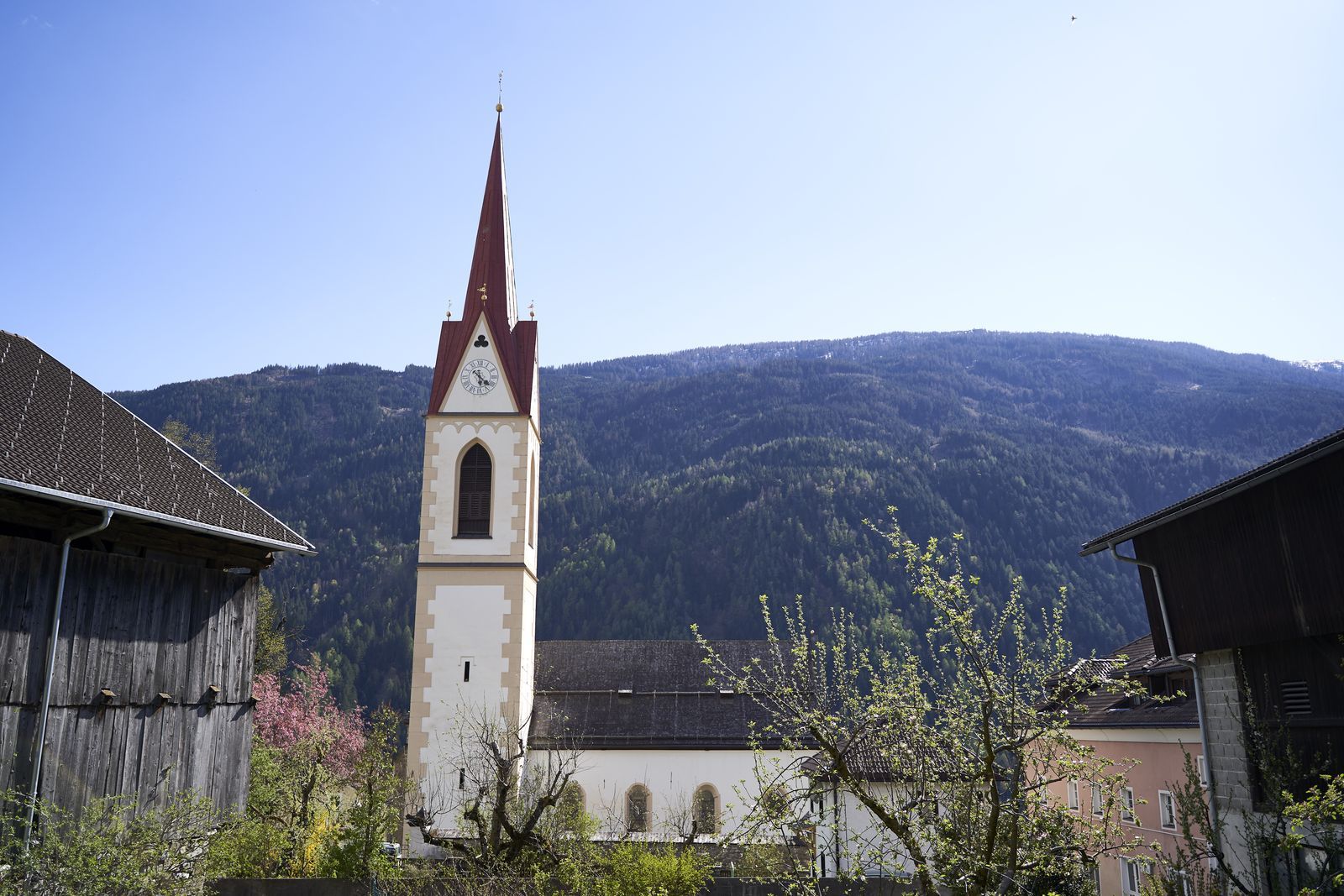 Kirche vor Bergrücken und blauem Himmel