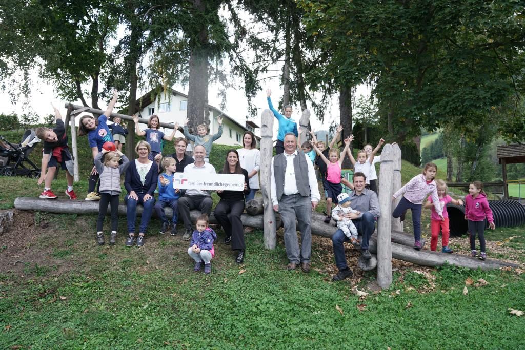 Eine Gruppe von Menschen, Erwachsene und Kinder auf einem Spielplatz