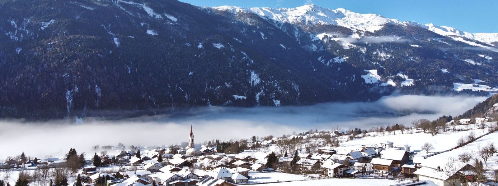 Luftaufnahme im Herbert der Gemeinde Oberlienz mit der Kirche im Zentrum.