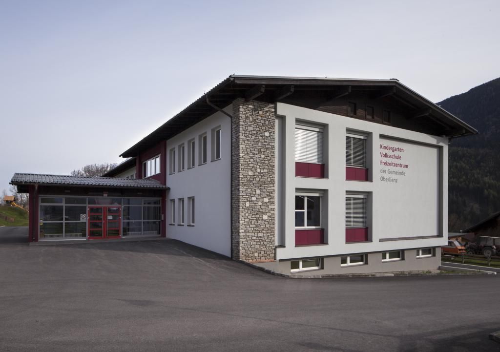 2-geschößiges Gebäude Volksschule Oberlienz, links Eingangsbereich mit Glasfront.